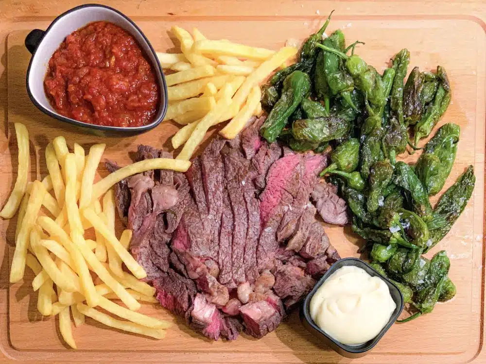 ribeye met salsa brava en pimientos de Padrón
