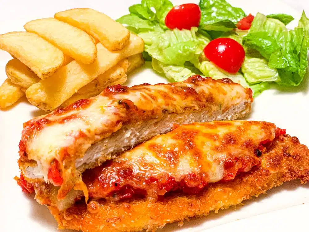 Schnitzel Parmigiana met tomatensaus en gesmolten mozzarella