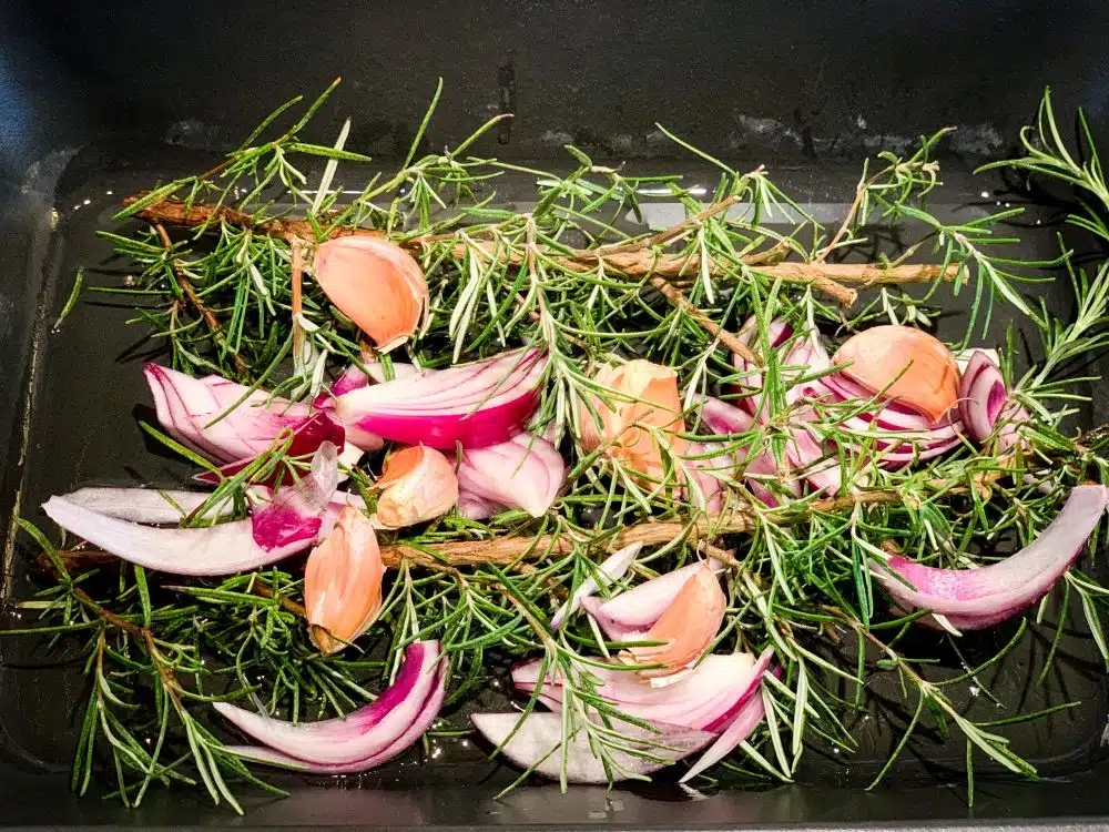 Bedje van rozemarijn en knoflook voor lamsschouder uit de oven Bedje van rozemarijn en knoflook voor lamsschouder uit de oven