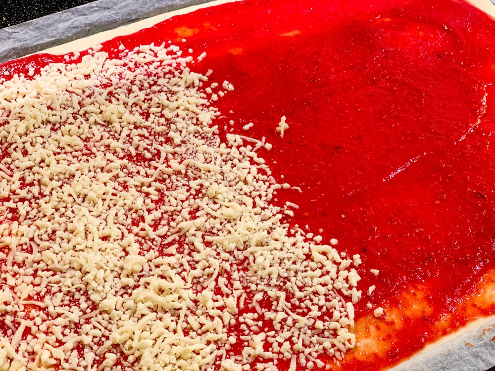 Pizzadeeg - tomatensaus - geraspte mozzarella