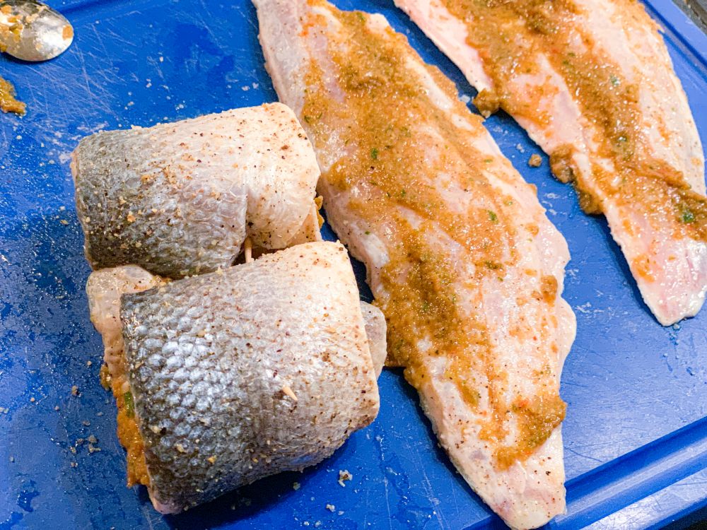 Vis insmeren met Bajan Seasoning en oprollen