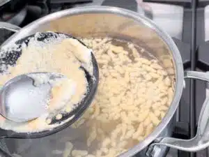 deeg voor Spätzle door een schuimspaan drukken deeg voor Spätzle door een schuimspaan drukken