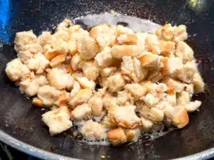 migas de pan – stap 5 ingeweekt oud brood in de pan doen