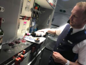 KLM-purser schenkt de wijnen in in de business class